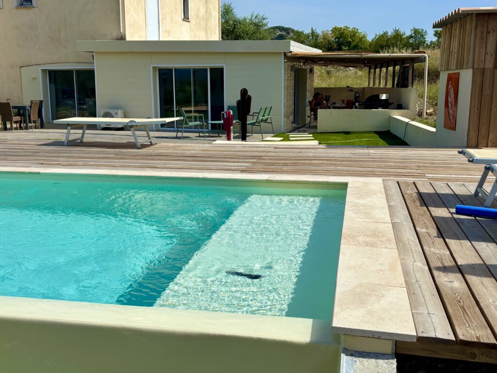Blick vom Pool auf das Ferienhaus und die Terrasse